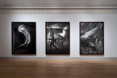 Installation view of “Robert Longo: A History of the Present,” 2021, at Guild Hall in East Hampton, New York, showing examples from the artist's charcoal-drawing series, “The Agency of Faith.”